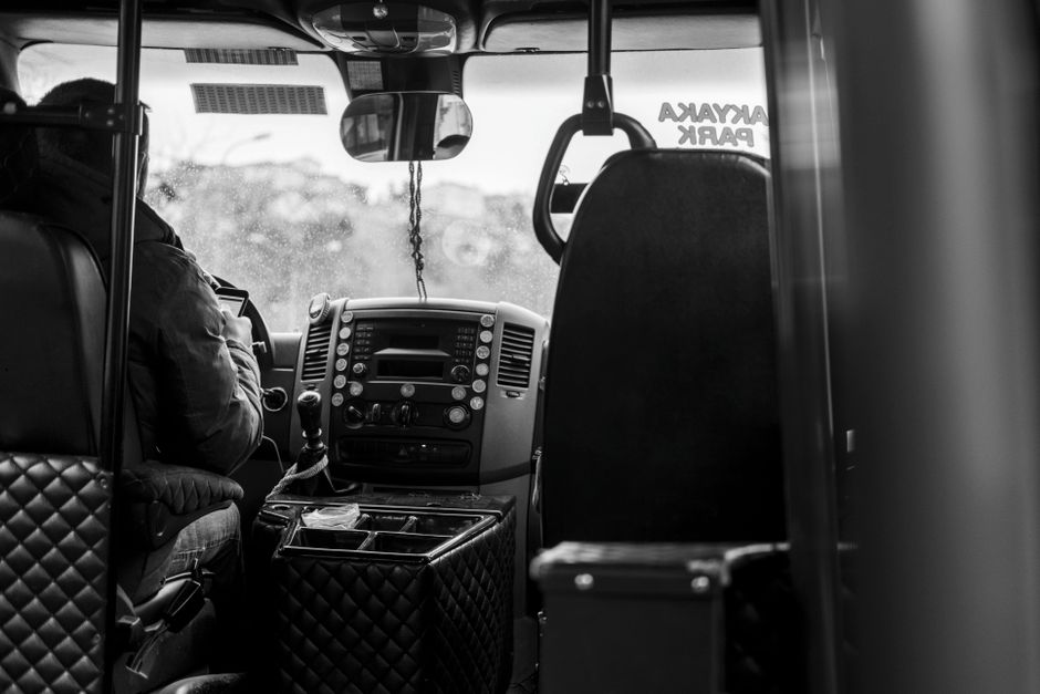 Een buschauffeur aan het werk in een moderne bus, met passagiers in het openbaar vervoer.